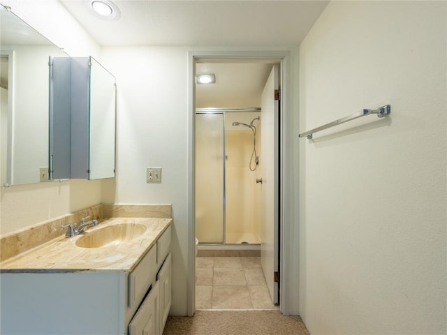 bathroom with tile patterned floors, vanity, and a shower with door