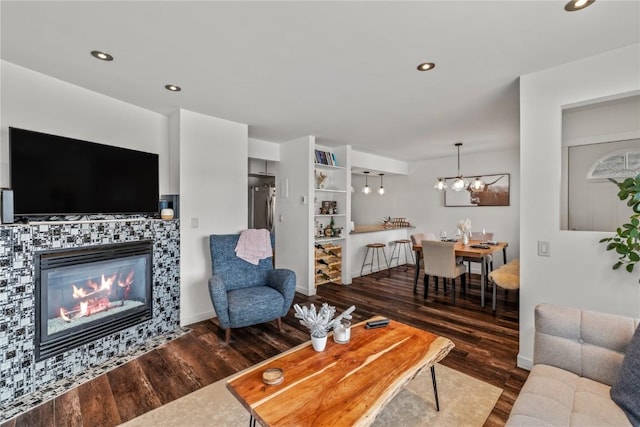 living room featuring dark hardwood / wood-style floors, an inviting chandelier, and a fireplace