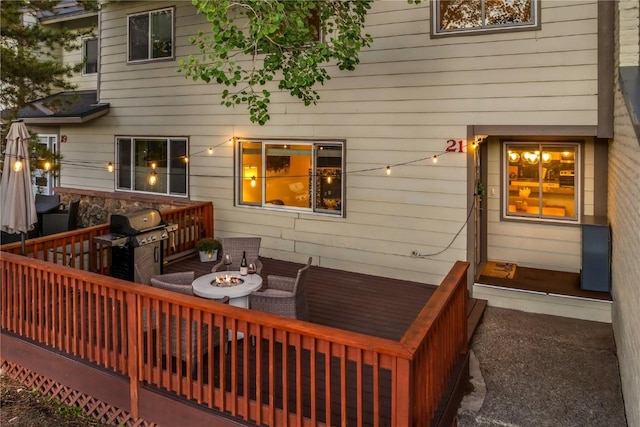 wooden terrace with area for grilling and a fire pit