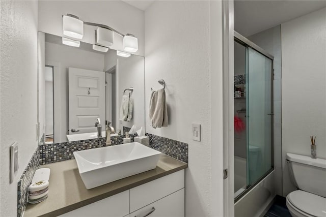 full bathroom with vanity, toilet, and combined bath / shower with glass door