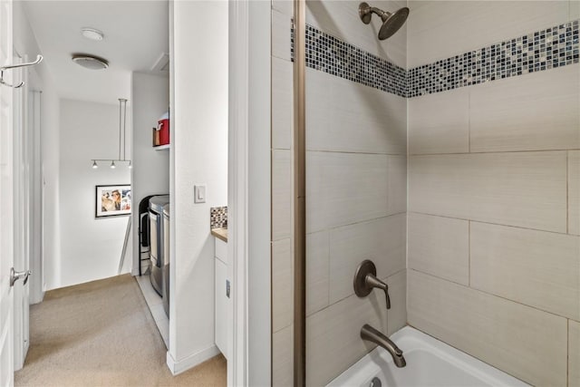 bathroom featuring vanity, independent washer and dryer, and tiled shower / bath