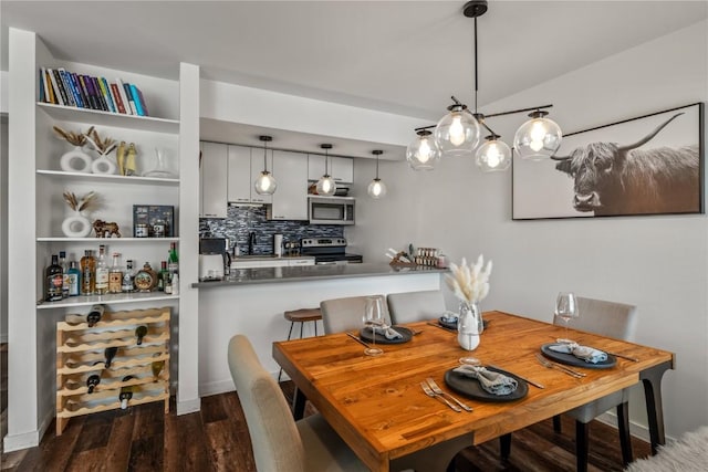 dining space featuring lofted ceiling and dark hardwood / wood-style floors