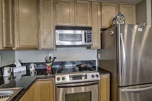 kitchen featuring appliances with stainless steel finishes, sink, and dark stone counters