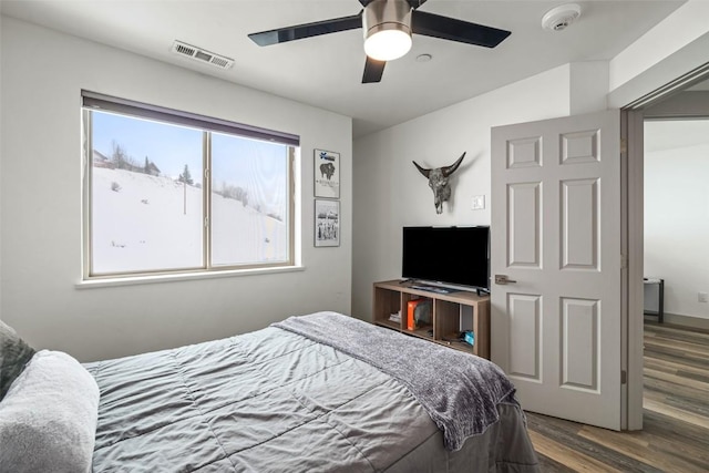 bedroom with dark wood-type flooring, visible vents, and a ceiling fan