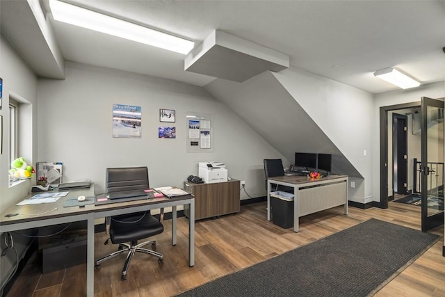 office featuring vaulted ceiling, wood finished floors, and baseboards