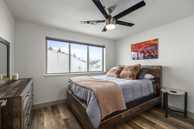 bedroom with dark wood-style floors, ceiling fan, and baseboards