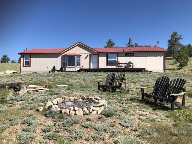 rear view of house with a fire pit and a deck