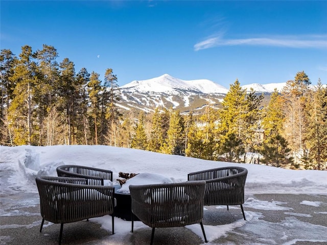 snow covered patio with a mountain view