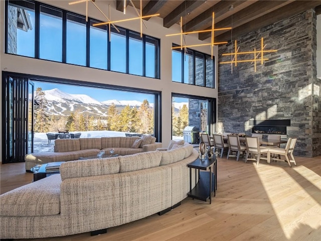 living room featuring a mountain view, beam ceiling, wood-type flooring, and a high ceiling