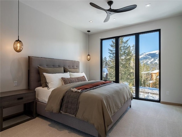 carpeted bedroom featuring ceiling fan, a mountain view, access to outside, and multiple windows