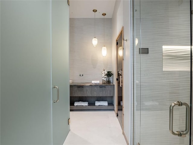 bathroom with a shower with door and tile walls