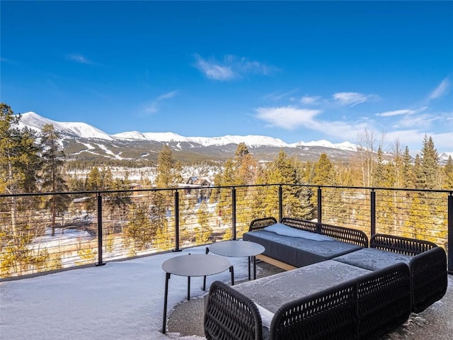 snow covered back of property with a mountain view