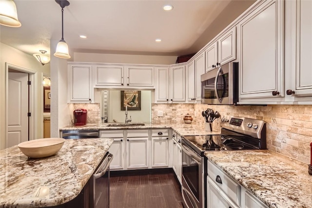 kitchen featuring white cabinetry, sink, hanging light fixtures, stainless steel appliances, and backsplash