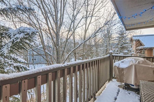 snow covered back of property featuring grilling area