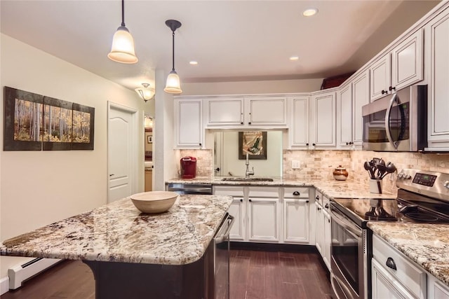 kitchen with decorative backsplash, appliances with stainless steel finishes, sink, decorative light fixtures, and white cabinetry