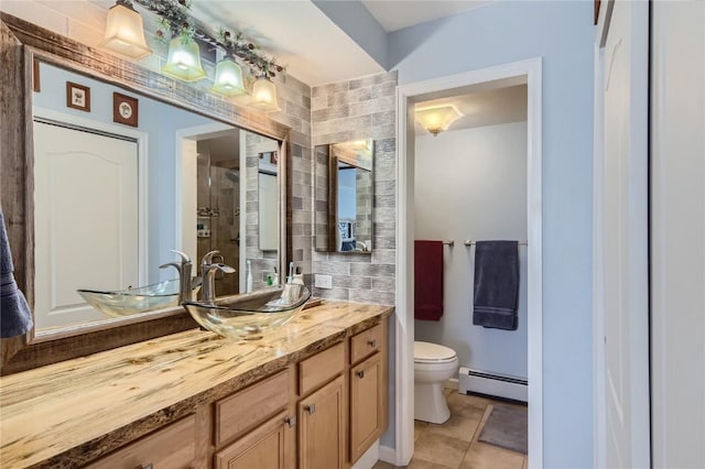 bathroom featuring tile patterned floors, walk in shower, vanity, a baseboard heating unit, and toilet