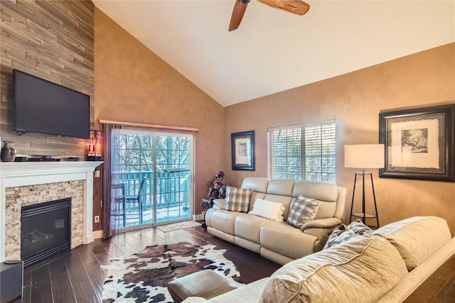 living room featuring a stone fireplace, ceiling fan, high vaulted ceiling, and dark hardwood / wood-style floors