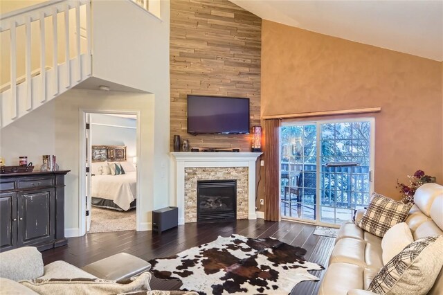 living room featuring a stone fireplace, dark wood-type flooring, and high vaulted ceiling