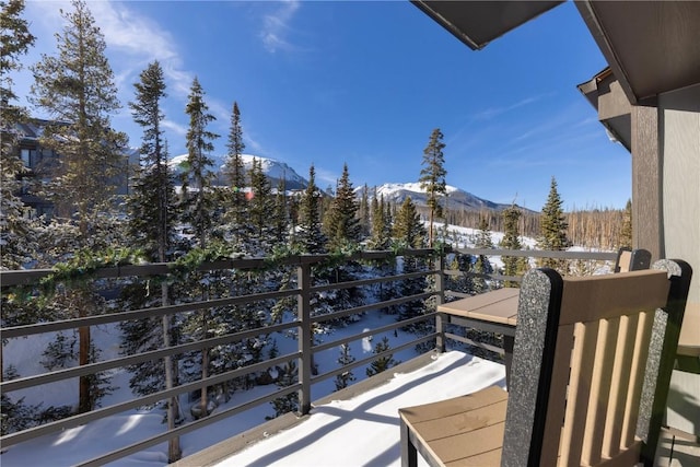 snow covered back of property with a mountain view