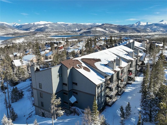 snowy aerial view featuring a residential view and a mountain view