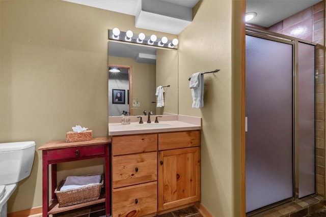 bathroom featuring vanity, toilet, and a shower with door