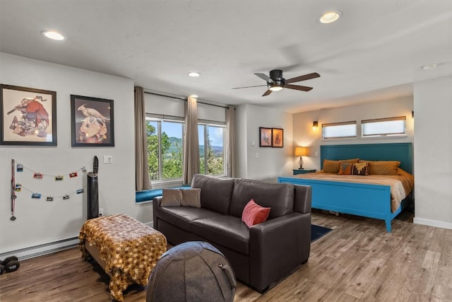 bedroom featuring ceiling fan, hardwood / wood-style floors, and a baseboard radiator