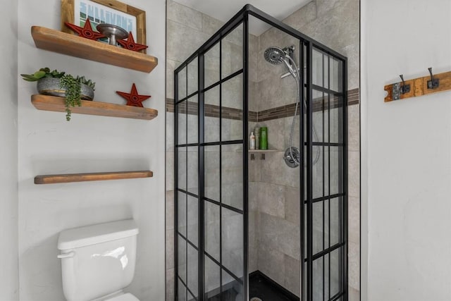 bathroom featuring toilet and tiled shower