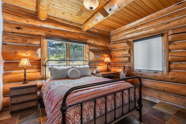 bedroom featuring beamed ceiling, wooden ceiling, and log walls