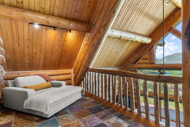 sitting room featuring rustic walls, lofted ceiling with beams, a mountain view, wood walls, and wood ceiling