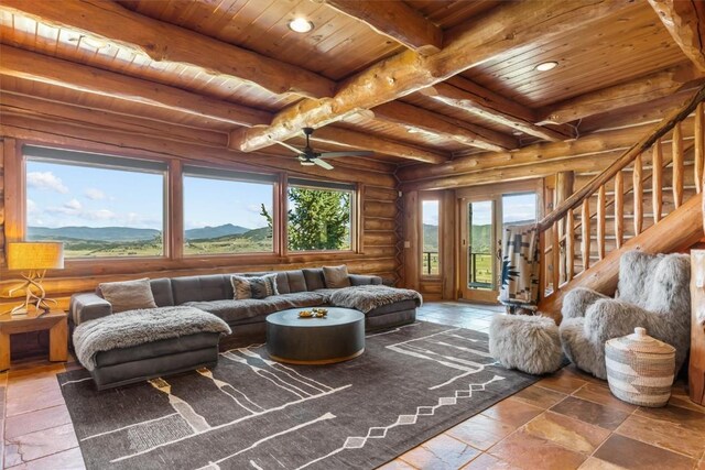 living room with wood ceiling, ceiling fan, log walls, beam ceiling, and a mountain view