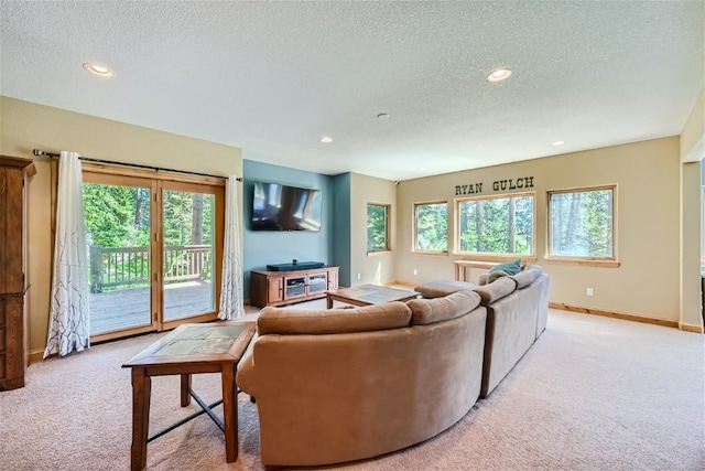 living room with a wealth of natural light, light carpet, and a textured ceiling