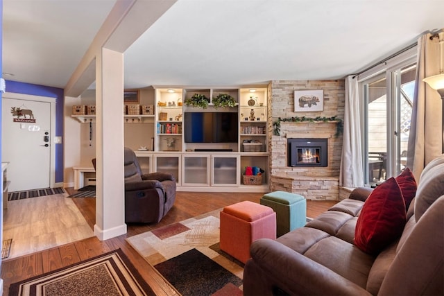 living room featuring hardwood / wood-style flooring and a stone fireplace