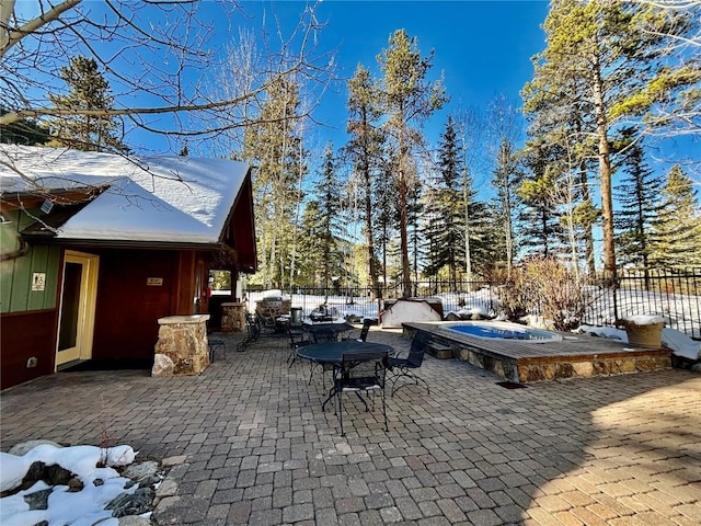 snow covered patio featuring a hot tub