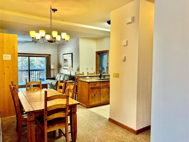 carpeted dining room featuring a chandelier and sink