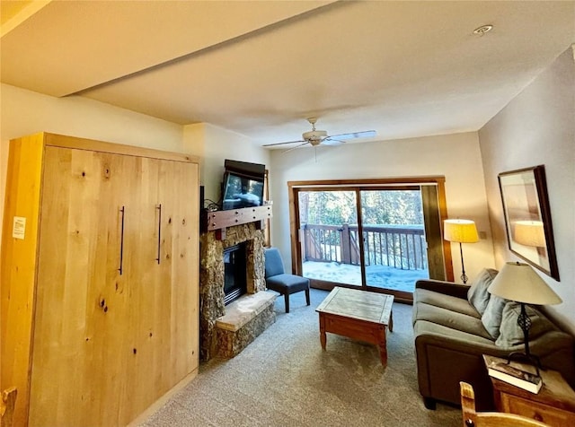 living room with a fireplace, carpet flooring, and ceiling fan