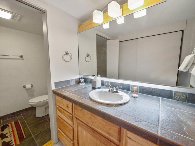 bathroom featuring vanity, toilet, and tile patterned flooring