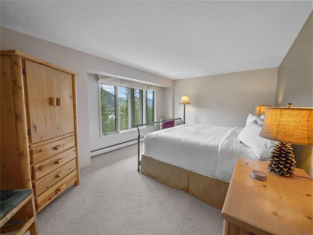 bedroom with a baseboard heating unit and light colored carpet