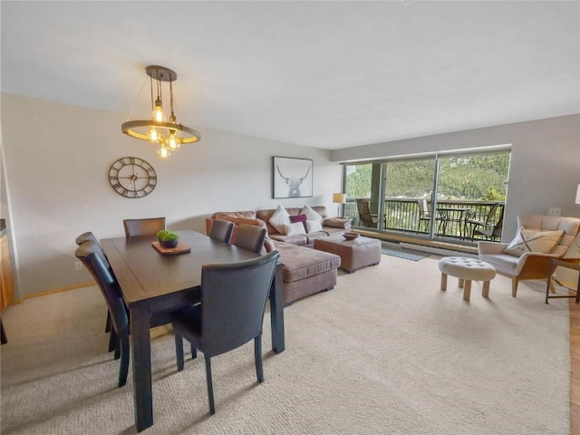 carpeted dining area with a chandelier