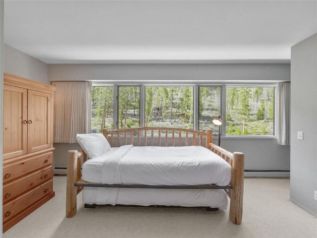 bedroom with a baseboard radiator and light colored carpet