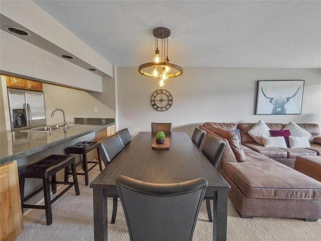 dining area with sink and light carpet