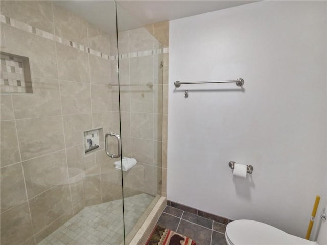 bathroom with toilet, a shower with shower door, and tile patterned flooring