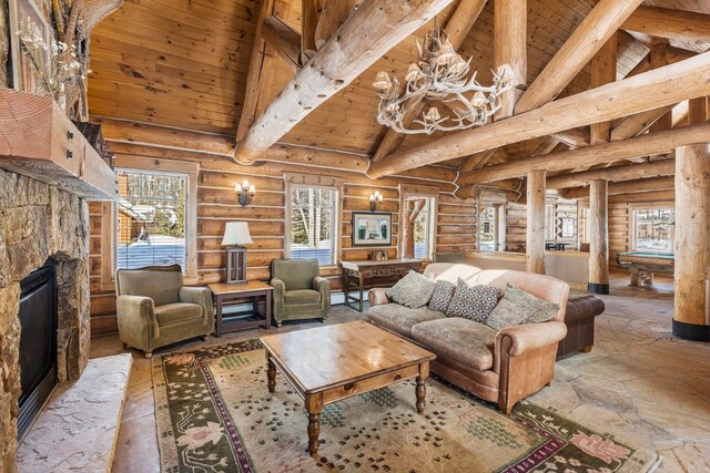 living room with billiards, wooden ceiling, stone tile flooring, a stone fireplace, and beam ceiling