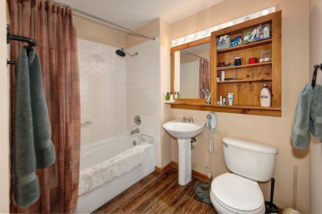 full bathroom featuring sink, hardwood / wood-style flooring, toilet, and shower / bath combo with shower curtain