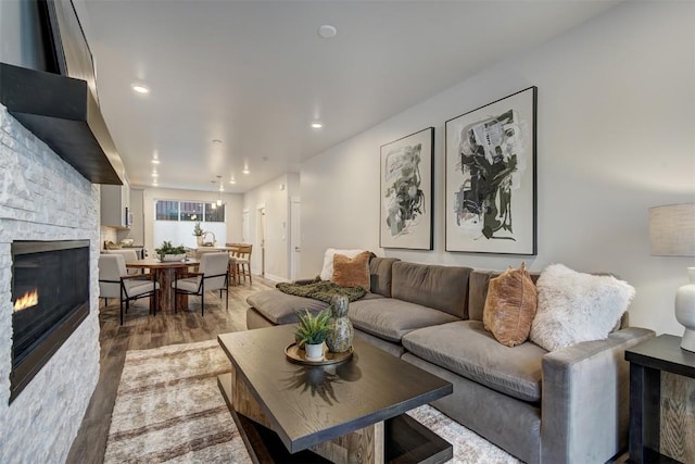 living room with a stone fireplace and hardwood / wood-style floors