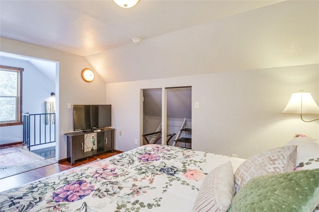 bedroom featuring dark wood-style floors, baseboards, and lofted ceiling