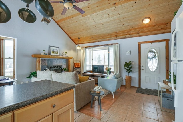 foyer entrance with ceiling fan, light tile patterned floors, a tile fireplace, wooden ceiling, and high vaulted ceiling