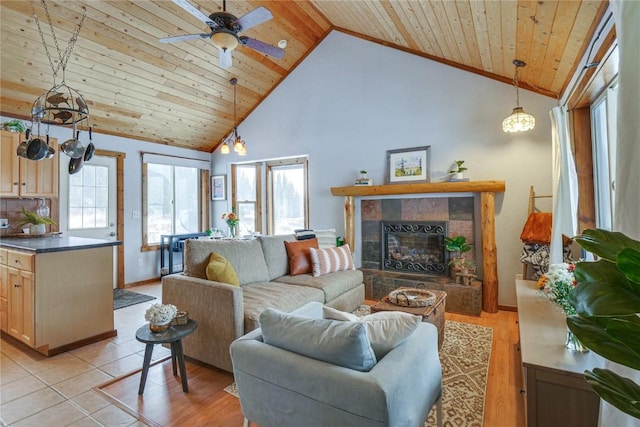 living area with light wood finished floors, high vaulted ceiling, ceiling fan, a tile fireplace, and wooden ceiling