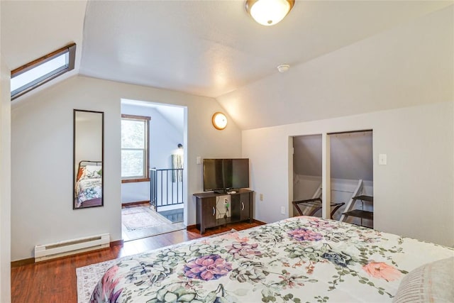 bedroom featuring a baseboard heating unit, vaulted ceiling with skylight, and wood finished floors