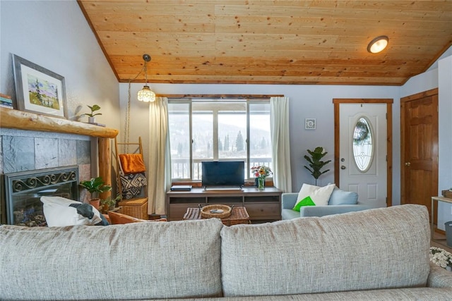 living room featuring lofted ceiling, wooden ceiling, and a tile fireplace