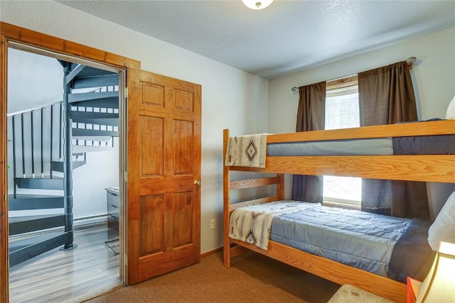 bedroom featuring baseboards, carpet floors, and a textured ceiling